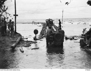 LAE AREA, NEW GUINEA. 1945-01-28. DICK BENTLEY, FAMOUS AUSTRALIAN ENTERTAINER AND MEMBERS OF HIS CONCERT PARTY CHATTING WITH NX135533 CAPTAIN E.G.M. CUPIT, DEPUTY ASSISTANT DIRECTOR OF EDUCATION, ..