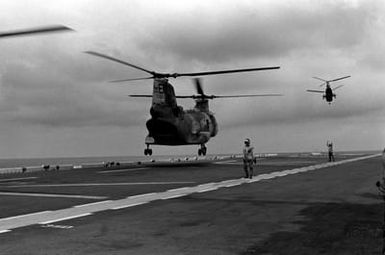 Two CH-46E Sea Knight helicopters of Marine Medium Helicopter Squadron 261 (HMM-261) lift off from the flight deck of the amphibious assault ship USS SAIPAN (LHA 2) during a rehearsal for Operation Sharp Edge. The SAIPAN is on station off the coast of Liberia