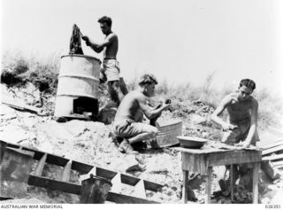 NEW GUINEA, 1942-08. WASHING DAY IN NEW GUINEA. AUSTRALIAN SOLDIERS RUBBING, SCRUBBING AND BOILING THEIR SHIRTS AND SHORTS