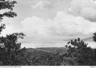 MILNE BAY, NEW GUINEA. 1943-03. A VIEW OF THE BAY FROM THE HILL STATION ROAD. IN THE CENTRE MIDDLE DISTANCE IS TURNBULL FIELD, NAMED AFTER SQUADRON LEADER PETER TURNBULL, DFC, COMMANDING OFFICER, ..