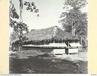 LAE, NEW GUINEA. 1944-07-01. STANDARD DESIGN OFFICER'S MESS AT HEADQUARTERS, NEW GUINEA FORCE. THIS BUILDING IS CONSTRUCTED ENTIRELY OF BUSH TIMBER AND SISALCRAFT WITH A PALM THATCHED ROOF AND A ..