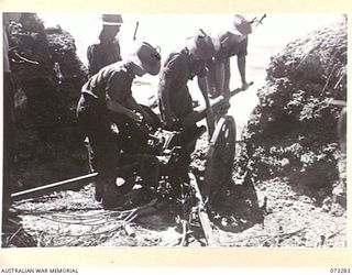 ALEXISHAFEN, NEW GUINEA. 1944-05-17. PERSONNEL OF THE 35TH INFANTRY BATTALION EXAMINE A CAPTURED JAPANESE ANTI TANK GUN AT THE MOUTH OF THE REMPI RIVER NORTH OF ALEXISHAFEN