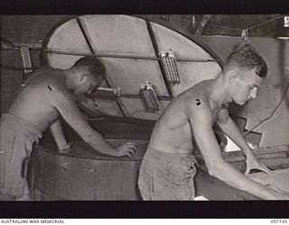 SEVENTEEN MILE, NEW GUINEA. 1943-09-23. VX19898 SERGEANT C. E. WATSON (LEFT) AND VX21244 SAPPER R. GILCHRIST OF THE 2/1ST AUSTRALIAN ARMY TOPOGRAPHICAL SURVEY COMPANY PREPARING TO SENSITIZE A ZINC ..