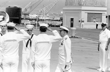 ADM Sylvester R. Foley Jr. walks through two rows of side boys at the conclusion of the ceremony marking the assumption of command of the U.S. Pacific Fleet