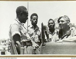 SOUTHPORT, QLD. 1944-01-18. SX23647 SERGEANT M. HAILSTONE OF THE 4TH ARMOURED BRIGADE DEMONSTRATING THE TANK WIRELESS EQUIPMENT TO SEVERAL NEW GUINEA POLICE BOYS