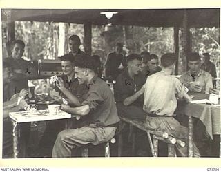 WAREO, PAPUA, NEW GUINEA, 1944-03-29. TROOPS AT B COMPANY, 4TH FIELD AMBULANCE REST CAMP RELAXING IN THE RED CROSS RECREATION HUT WHICH IS WELL SUPPLIED WITH AMUSEMENTS, A RADIO SET, AND GAMES. A ..