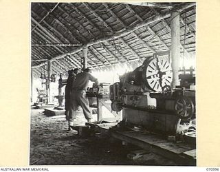 LABU, NEW GUINEA, 1944-03-10. NX65799 CORPORAL P.A. ROGAN (1), AND QX27843 SERGEANT G.T. PAGE (2), FITTERS AT THE 1ST WATERCRAFT WORKSHOP, AUSTRALIAN ELECTRICAL AND MECHANICAL ENGINEERS, FITTING ..