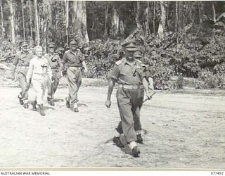 TOROKINA, BOUGAINVILLE ISLAND. 1944-12-06. VX38969 MAJOR-GENERAL W. BRIDGEFORD, CBE, MC, GOC, 3RD DIVISION (1) WITH SENIOR AUSTRALIAN AND AMERICAN ARMY OFFICERS WALKING OUT ONTO THE PARADE GROUND ..