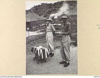 WEWAK POINT, NEW GUINEA. 1945-10-02. LIEUTENANT W.C.J. WHITE, ADJUTANT (2), READING THE CITATIONS TO MEMBERS OF C COMPANY, 2/3 MACHINE-GUN BATTALION, DURING THE PRESENTATION OF MILITARY MEDALS TO ..