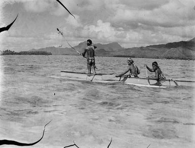 [Three men fish off Ra'iātea Island in an outrigger canoe]