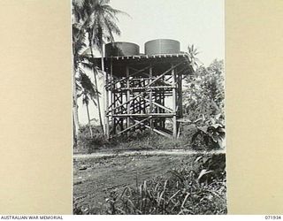 MILNE BAY, PAPUA, NEW GUINEA. 1944-04-03. WATER TANKS ON STANDS AT THE 2ND BULK PETROLEUM STORAGE COMPANY. THE TANKS PROVIDE FRESH WATER TO VISITING SHIPS