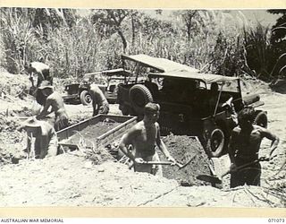 FINISTERRE RANGES, NEW GUINEA. 1944-03-15. TROOPS OF NO. 2 PLATOON, 2/4TH FIELD COMPANY, LOADING FROM THE GRAVEL PIT NEAR THE EVAPIA RIVER. GRAVEL FOR THE EVAPIA RIVER TO KESAWAI ROAD IS DUG FROM ..