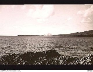 FINSCHHAFEN, NEW GUINEA. 1943-09-23. EXPLOSION OF BOMBS DROPPED BY BOSTON BOMBER AIRCRAFT OF THE RAAF, ON THE AERODROME AND JETTY AFTER A HEAVY DIVE BOMBING ATTACK BY VULTEE VENGEANCE DIVE BOMBER ..