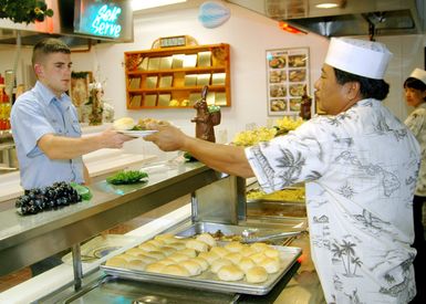 US Navy (USN) Machinist Mate 3rd Class (MM3) Brandon Oyer, assigned to the USN Los Angeles Class Attack Submarine USS HONOLULU (SSN 718), is handed an award winning meal at Pearl Harbor's Silver Dolphin Bistro Galley, at Pearl Harbor, Hawaii (HI)
