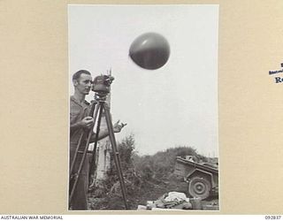 WEWAK AREA, NEW GUINEA, 1945-06-05. WO C.J. PADDICK, 3 MOBILE METEOROLOGICAL FLIGHT, RAAF, ATTACHED HQ ROYAL AUSTRALIAN ARTILLERY 6 DIVISION, RELEASING A HYDROGEN FILLED BALLOON FOR OBSERVATION OF ..