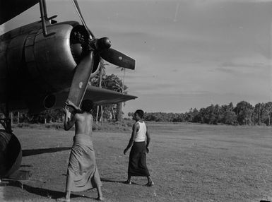 [Two Pacific Island men next to plane]