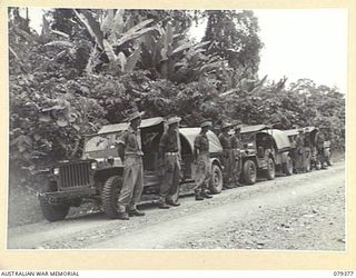 LAE, NEW GUINEA. 1945-03-11. PERSONNEL OF THE 34TH WIRELESS SECTION (HEAVY), 19TH LINES OF COMMUNICATION SIGNALS PARADING ON THE ROADSIDE WITH A WS133 TRANSMITTER PACKED IN THREE JEEPS AND ..