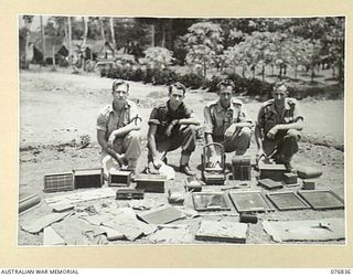 LAE, NEW GUINEA. 1944-11-11. THE THREE CARPENTERS AND THE ONE HOBBIES INSTRUCTOR OF THE 112TH CONVALESCENT DEPOT DISPLAY SOME OF THE MANY AND VARIED ARTICLES MADE BY PATIENTS OF THE UNIT. ..