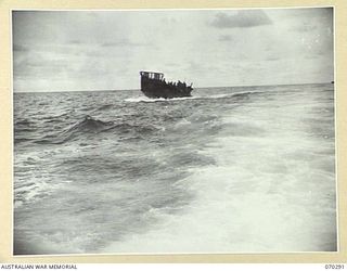 KELANOA AND BUTUBUTU, NEW GUINEA, 1944-02-08. A BARGE LOADED WITH TROOPS AND STORES OF HEADQUARTERS 5TH DIVISION SIGNALS, IN A ROUGH SEA BETWEEN KELANOA AND BUTUBUTU