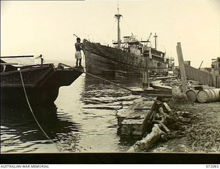 MILNE BAY, NEW GUINEA. 1944-04-05. THE MOTOR VESSEL "ANSHUN" FLOATING AT A WHARF AFTER BEING RAISED FROM THE HARBOUR BY THE COMMONWEALTH SALVAGE MARINE SERVICE. THE SHIP, SUNK BY SHELLFIRE FROM A ..