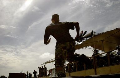 U.S. Air Force 36th Communication Squadron, 36th Air Expeditionary Wing, SENIOR AIRMAN Christopher Berry races through a high step tire obstacle carrying a 5.62 mm M-16A2 rifle during Warrior Day Challenge at Arch Light Memorial Park, Andersen Air Force Base, Guam, on Jan. 14, 2005. (U.S. Air Force PHOTO by STAFF SGT. Bennie J. Davis, III) (RELEASED)