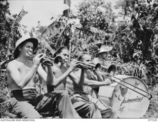 BOUGAINVILLE ISLAND. 1944-12-07. THE BRASS SECTION OF THE SWING BAND OF THE "TASMANIACS" - THE TASMANIA LINES OF COMMUNICATION CONCERT PARTY REHEARSING IN A JUNGLE CLEARING IN PREPARATION FOR THE ..