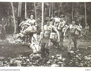 SAMPUN, NEW BRITAIN. 1945-01-27. TROOPS OF THE 6TH FIELD AMBULANCE MOVING DOWN THE BEACH TO BOARD AN LCM (LANDING CRAFT MECHANISED) FOR THE NIGHT LANDING AT KIEP PLANTATION. IDENTIFIED PERSONNEL ..