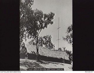 PORT MORESBY, PAPUA, C. 1942. HEADQUARTERS OF THE NEW GUINEA AIR WARNING WIRELESS COMPANY (NGAWW), SHOWING THE ADMINISTRATION BUILDING AND ITS TALL AERIAL