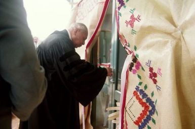 King Taufa'ahau Tupou IV, King of Tonga, entering church Vaine Mo'onia through a portal of fine mats