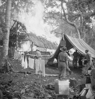 KILIGIA, NEW GUINEA. 1944-04-15. AN OUTBREAK OF FIRE IN THE SALVATION ARMY RECREATION HUT AT HEADQUARTERS 5TH DIVISION WHICH LEFT THE HUT A SMOKING RUIN WITHIN 4 1/2 MINUTES. DESPITE THE RAPID ..