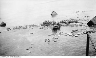 Oro Bay, Buna. Survivors of the Dutch cargo steamer 'sJacob, sunk by Japanese bombers, cling to wreckage awaiting rescue by the corvette HMAS Bendigo. (Naval Historical Collection)