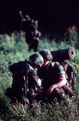 PH1 Ted Salois Tinian, Marianas Islands....Two Marines make some last-minute adjustments to their gear before they head into the jungle during exercise Kennel Bear '89. The Marines, from Marine Barracks Guam, are acting as aggressors against Seabees from Navy Mobile Construction Battalion 3 and Marines from the 3rd Force Service Support Group. OFFICIAL U.S. NAVY PHOTO (RELEASED)