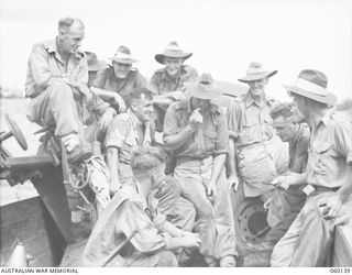 WARD'S DROME, NEW GUINEA. 1943-11-16. GUNNERS OF C TROOP, 2/5TH AUSTRALIAN FIELD REGIMENT, 7TH AUSTRALIAN DIVISION, ENJOY A SMOKE AFTER LOADING A LONG 25-POUNDER GUN INTO A DOUGLAS TRANSPORT ..