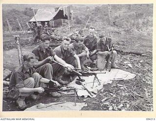 MOLONEY'S RIDGE, WEWAK, NEW GUINEA. 1945-07-13. TROOPS OF NO. 13 PLATOON, A COMPANY, 2/5 INFANTRY BATTALION, CLEANING THEIR WEAPONS AFTER THE SUCCESSFUL ASSAULT AGAINST THE JAPANESE-HELD KUNAI ..