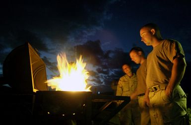 US Navy (USN) PETTY Officer Third Class (PO3) Jessica Young (left), PO3 Arthur Perry, and PETTY Officer Second Class (PO2) Ron Brown (right) stand over a makeshift grill during downtime at a US military camp in Harar, Ethiopia. USN Construction Battalion (SEABEE) with Naval Mobile Construction Battalion 3 (NMCB 3), Port Hueneme, California (CA), dug three wells and are staging to drill several hand-pump wells, to provide thousands of Ethiopians and their livestock with potable water. US Army (USA) Soldiers from 1ST Battalion (BN), 294th Infantry Division (ID), Bravo Company (B CO), Guam (GU), provide force protection at the camp and well sites so that the Seabees can concentrate their...