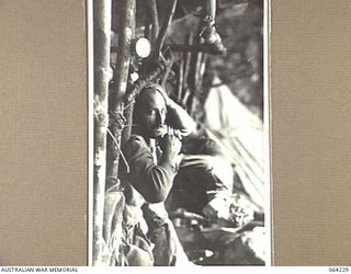 CANNINGS SADDLE, NEW GUINEA. 1944-01-22. PRIVATE STAGBOWER OF THE 2/12TH INFANTRY BATTALION RECEIVING TREATMENT AT CHEN'S POST AFTER A SUCCESSFUL ATTACK ON ENEMY POSITIONS IN THE AREA