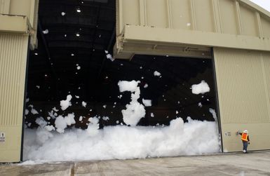 Doug Larsen a contractor with the Wolverine Fire Protection Company pulls an emergency lever to test a High Expansion (HI-EX) foam system used for fire protection inside aircraft hangars. The Jet Ex foam produced by the Ansul Corporation covers the hangar up to twelve feet high preventing the spread of fire