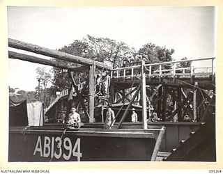 KALUMALAGI RIVER, JACQUINOT BAY, NEW BRITAIN, 1945-08-12. TROOPS AT 1 INFANTRY TROOPS WORKSHOP ERECTING A BARGE GANTRY AT THE BEACH SLIPWAY. THE GANTRY WILL BE USED TO LIFT BARGES FOR REPAIR