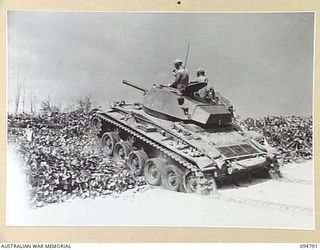 TOROKINA AREA, BOUGAINVILLE, 1945-08-06. AN M24 GENERAL CHAFFEE LIGHT TANK CLIMBING OFF THE BEACH AND UP AN EMBANKMENT DURING TRIALS CONDUCTED FOR THE WAR OFFICE