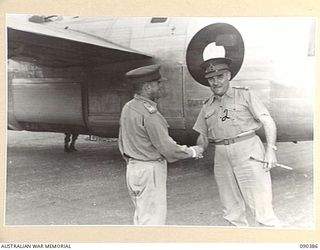JACQUINOT BAY, NEW BRITAIN. 1945-04-08. MAJOR GENERAL A.H. RAMSEY, GENERAL OFFICER COMMANDING 5 DIVISION (1), GREETS LIEUTENANT GENERAL NORTHCOTT, CHIEF OF THE GENERAL STAFF (2), AS HE LEAVES THE ..