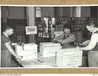 KENSINGTON, VIC. 1943-10-23. EMPLOYEES OF MESSRS KIMPTON & SONS FLOUR MILLS, NAILING AND WIRING CASES CONTAINING TWO TINS OF FLOUR FOR DESPATCH TO THE TROOPS IN NEW GUINEA