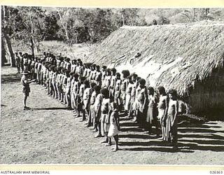 NEW GUINEA. 1942-08. SUPERFICIAL EXAMINATION OF NATIVE CARRIERS ON THE MORNING SICK PARADE BY THE REGIMENTAL AID POST ATTENDANT WARRANT OFFICER II. J.N. WALSHE. IN THESE DAYS WHEN LARGE NUMBERS OF ..