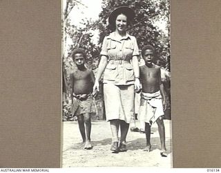 NEW GUINEA. 17 NOVEMBER 1943. BETTY COOK OF ADELAIDE, SA, TAKES LOCAL VILLAGE CHILDREN, VAKARAI AND LALOBA FOR A WALK