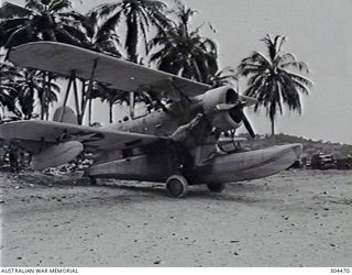 SEGI, NEW GEORGIA, SOLOMON ISLANDS. C.1943. A GRUMMAN J2F DUCK GENERAL PURPOSE AMPHIBIAN OF THE US NAVY IS PREPARING TO START UP AS A MECHANIC SWINGS THE STARTING CRANK. (NAVAL HISTORICAL ..