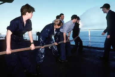 New crewmember SEAMAN (SN) Stormi Frusetta (left) receives some hands on experience in the use of a high pressure fire hose line during damage control training aboard the amphibious command ship USS BLUE RIDGE (LCC-191) while the ship is steaming off the island of Guam during exercise Tempo Brave '94