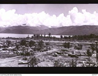 LAE, NEW GUINEA. 1943-10-04. SECTION PHOTOGRAPH OF THE WATERFRONT TAKEN FROM OBSERVATION HILL COVERS AIRSTRIP WITH TREES BEHIND IT, THEN SEA AND MOUNTAINS. TO JOIN PHOTOGRAPHS NOS. 57973, 57974, ..