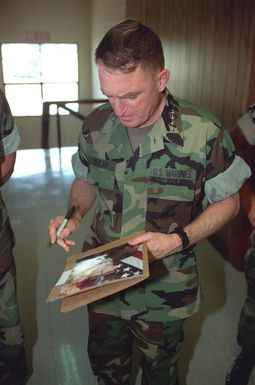 General Charles C. Krulak, 31st Commandant of the Marine Corps, stops to sign an autograph for a Marine while touring Kaneohe Bay on Marine Corps Base Hawaii