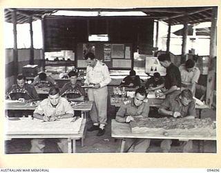 YALU, NEW GUINEA. 1945-08-03. FLYING OFFICER CRAIG-SMITH, GIVING INSTRUCTION TO STUDENTS IN THE TOPOGRAPHICAL WING AT THE NEW GUINEA TRAINING SCHOOL