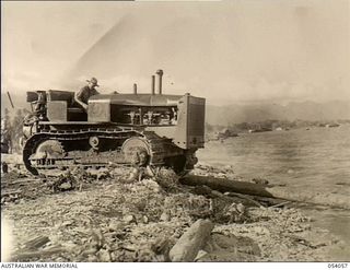 Gili Gili, Milne Bay. 1943-07-12. A large tractor, driven by V170934 Sapper L.A. Robb, during the construction of a large jetty to be 860 feet long. The work was carried out by the 4th Field ..