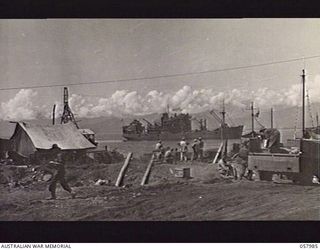 LAE, NEW GUINEA. 1943-10-12. THE WATERFRONT, TAKEN FROM THE SECTION OF THE 11TH OPERATIONAL GROUP, 1ST AUSTRALIAN WATER TRANSPORT GROUP, WITH THE TUNGSIN, THE FIRST MEDIUM SIZED SHIP TO DELIVER ..